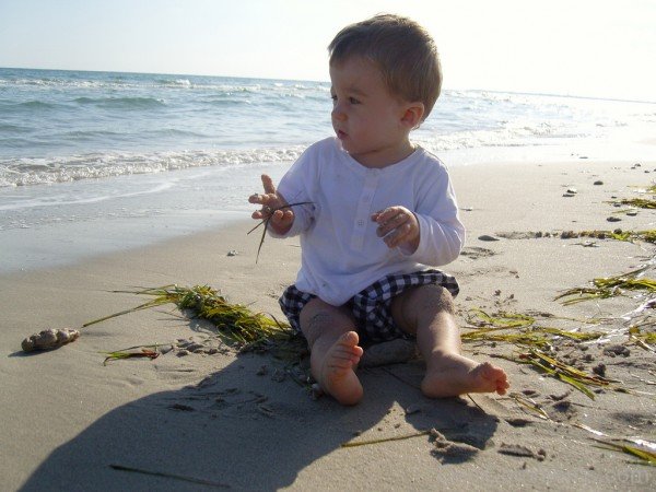 Baby Boy Sitting On Sand