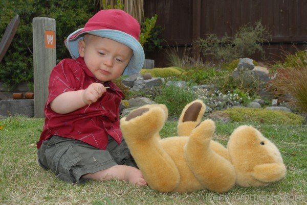 Baby Playing With Teddy In Garden