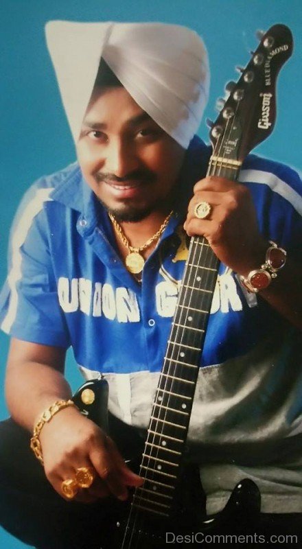 Lehmber Hussainpuri Holding Guitar